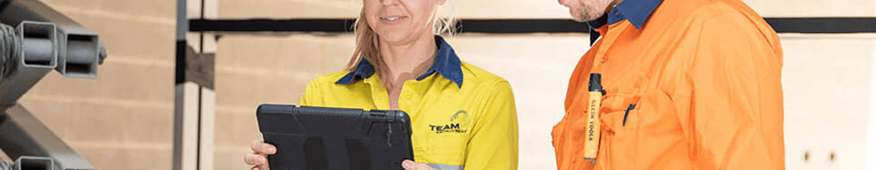a male and female electrician using EGTs online timesheet and payroll portal on a tablet device.
